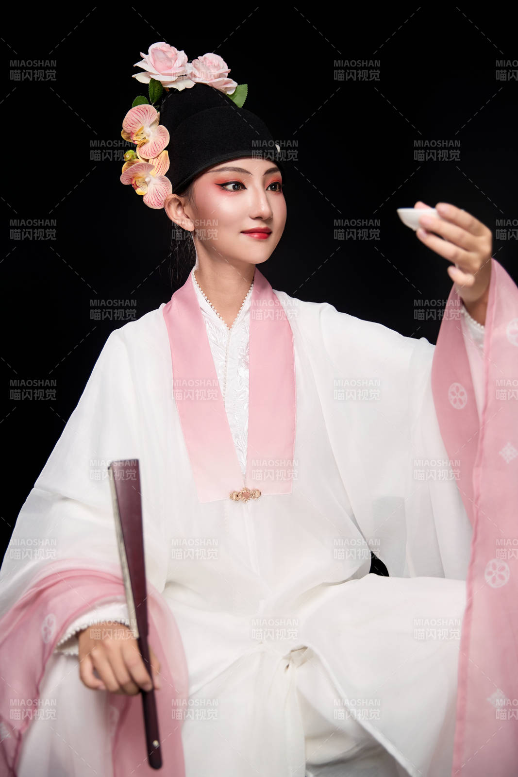 身著粵劇反串裝扮手持酒杯折扇的青年女性