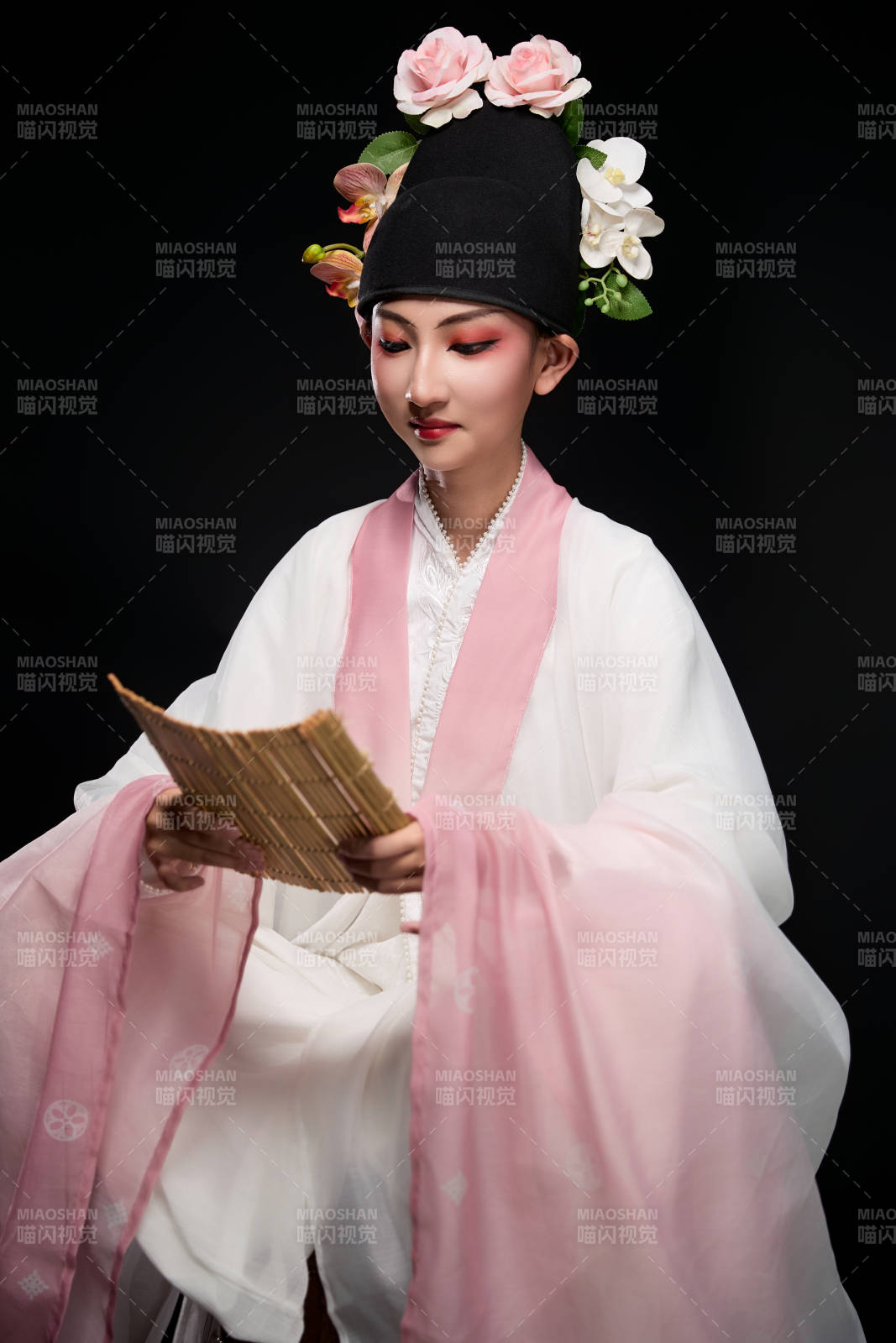 身著粵劇戲曲反串裝扮手持竹簡的青年女性