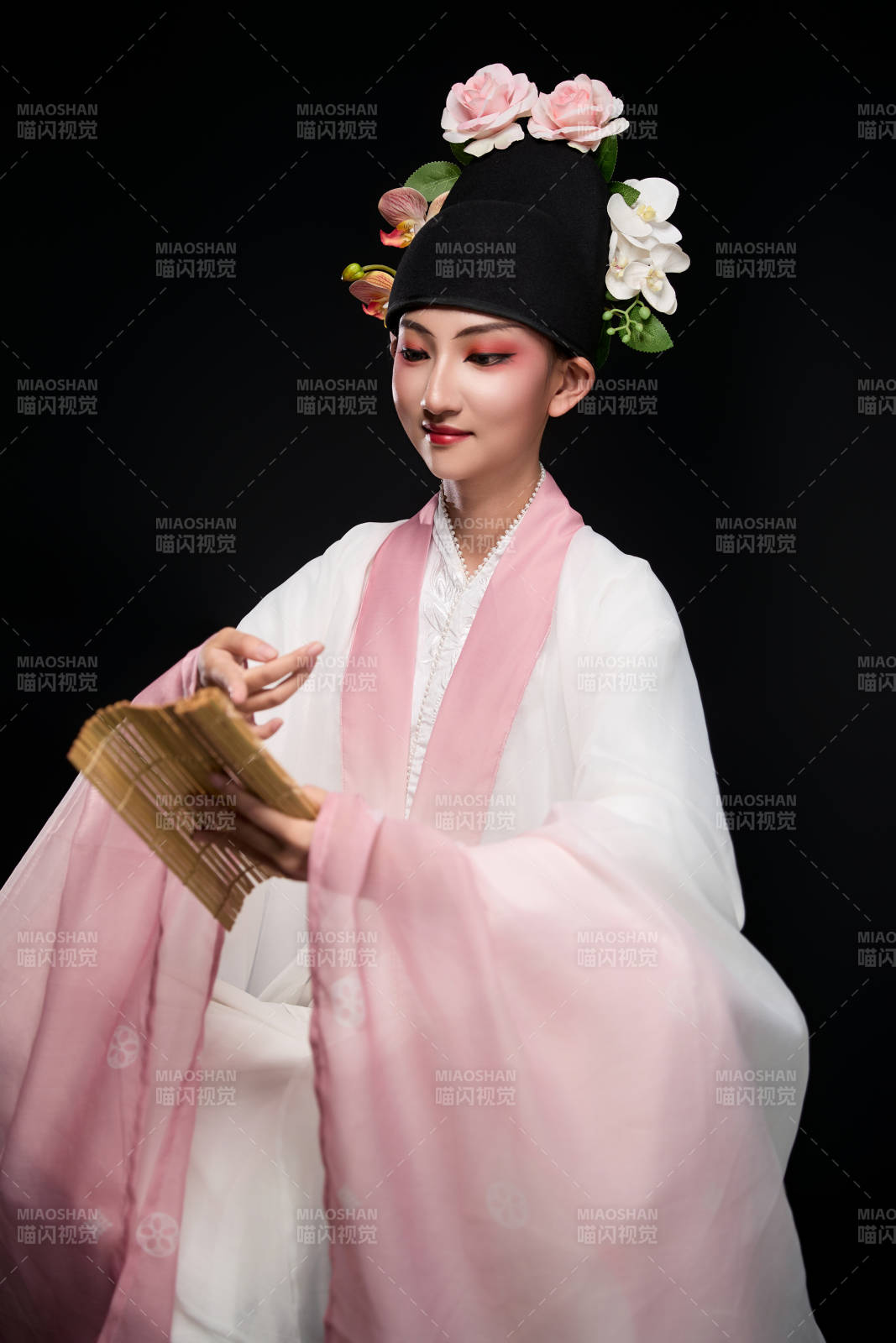 身著粵劇戲曲反串裝扮手持竹簡(jiǎn)的青年女性