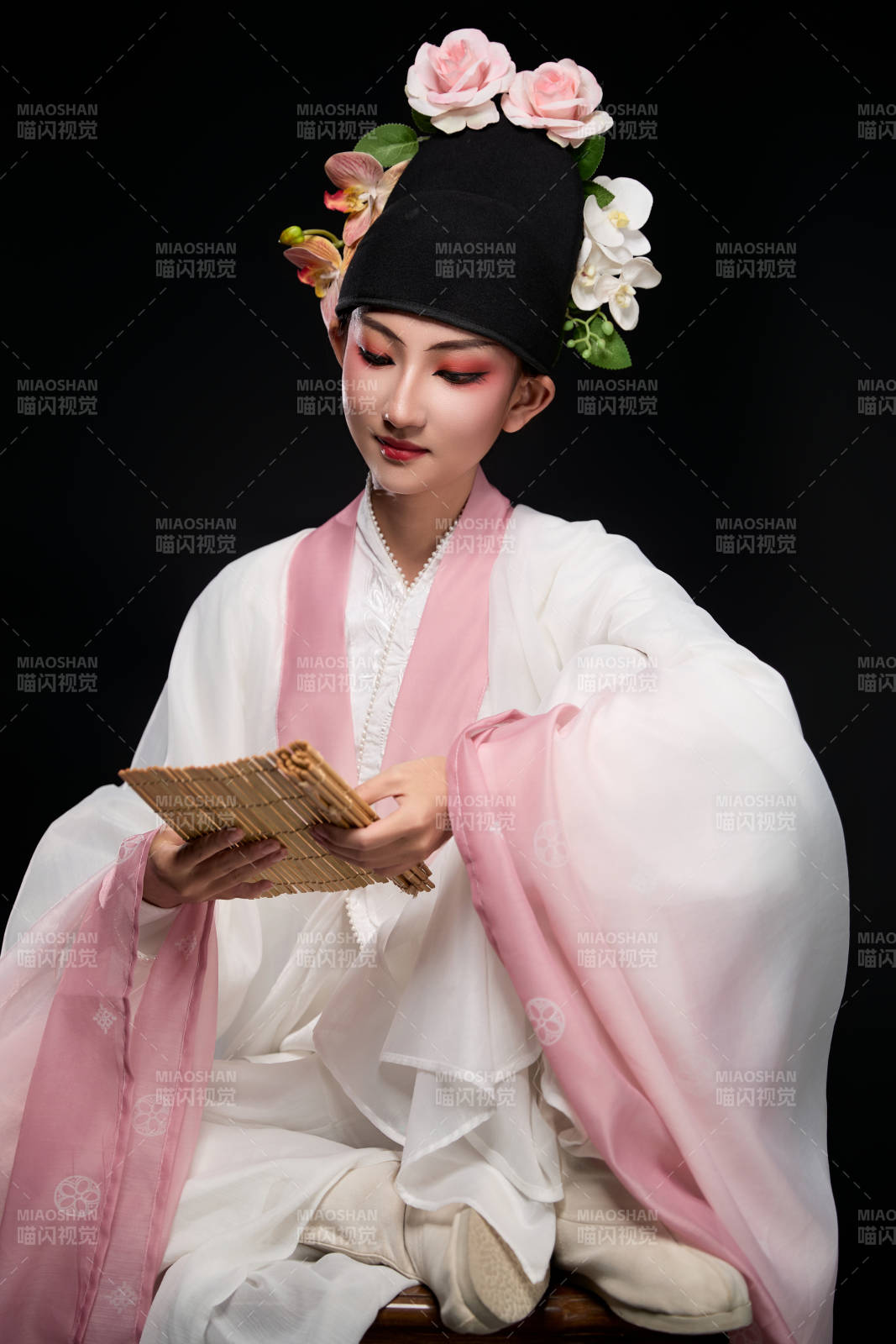 身著粵劇戲曲反串裝扮手持竹簡的青年女性