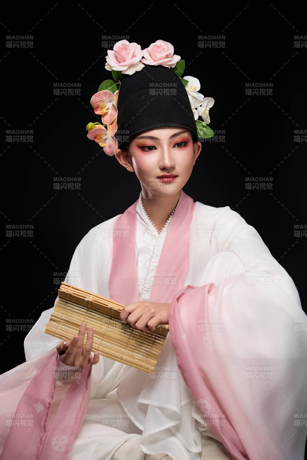 身著粵劇戲曲反串裝扮手持竹簡的青年女性