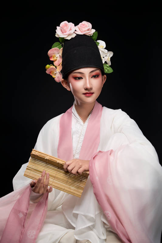 身着粤剧戏曲反串装扮手持竹简的青年女性