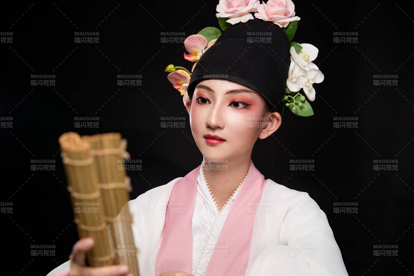 身著粵劇戲曲反串裝扮手持竹簡的青年女性