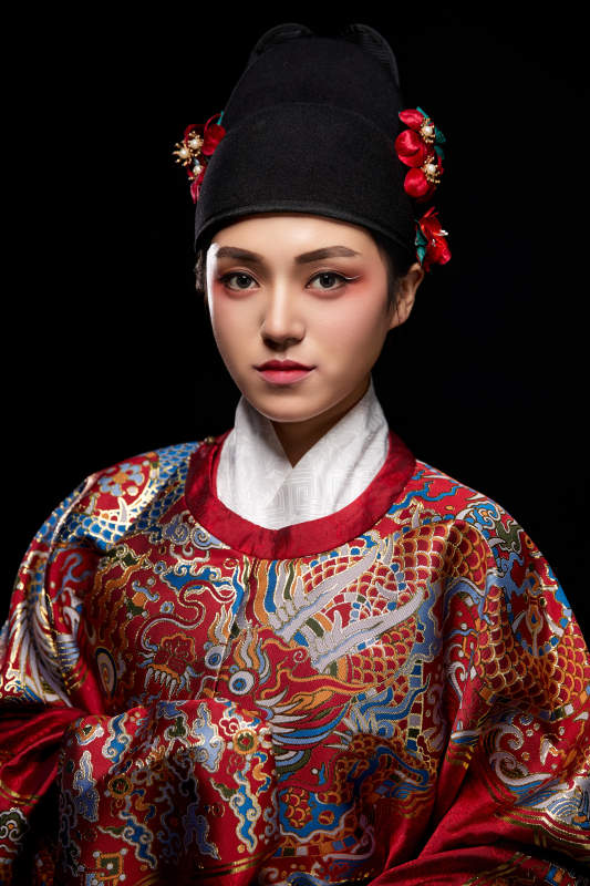 黑色背景下身着明代飞鱼服的青年女性