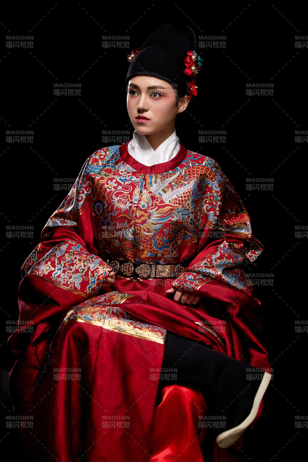 黑色背景下身著明代飛魚服的青年女性