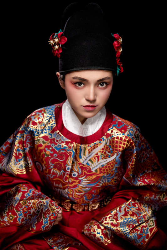 黑色背景下身着明代飞鱼服的青年女性