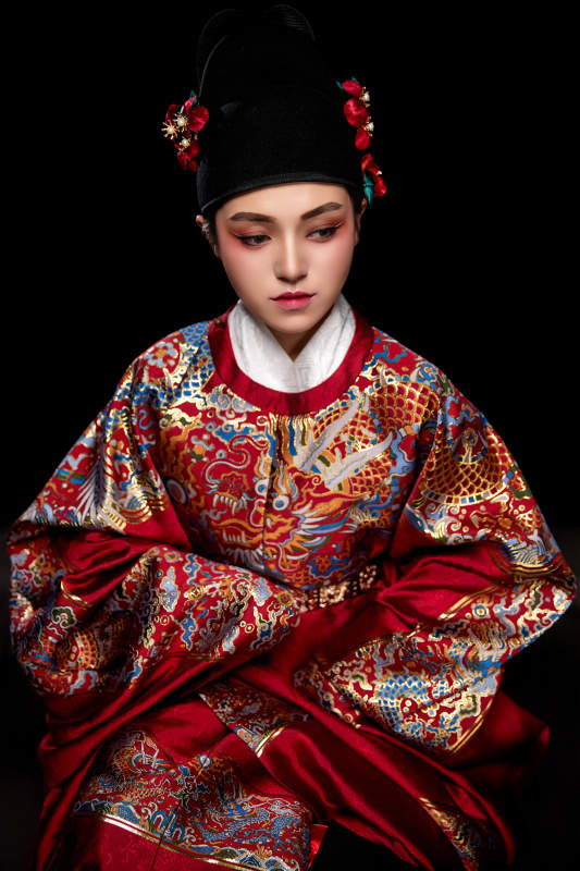 黑色背景下身着明代飞鱼服的青年女性