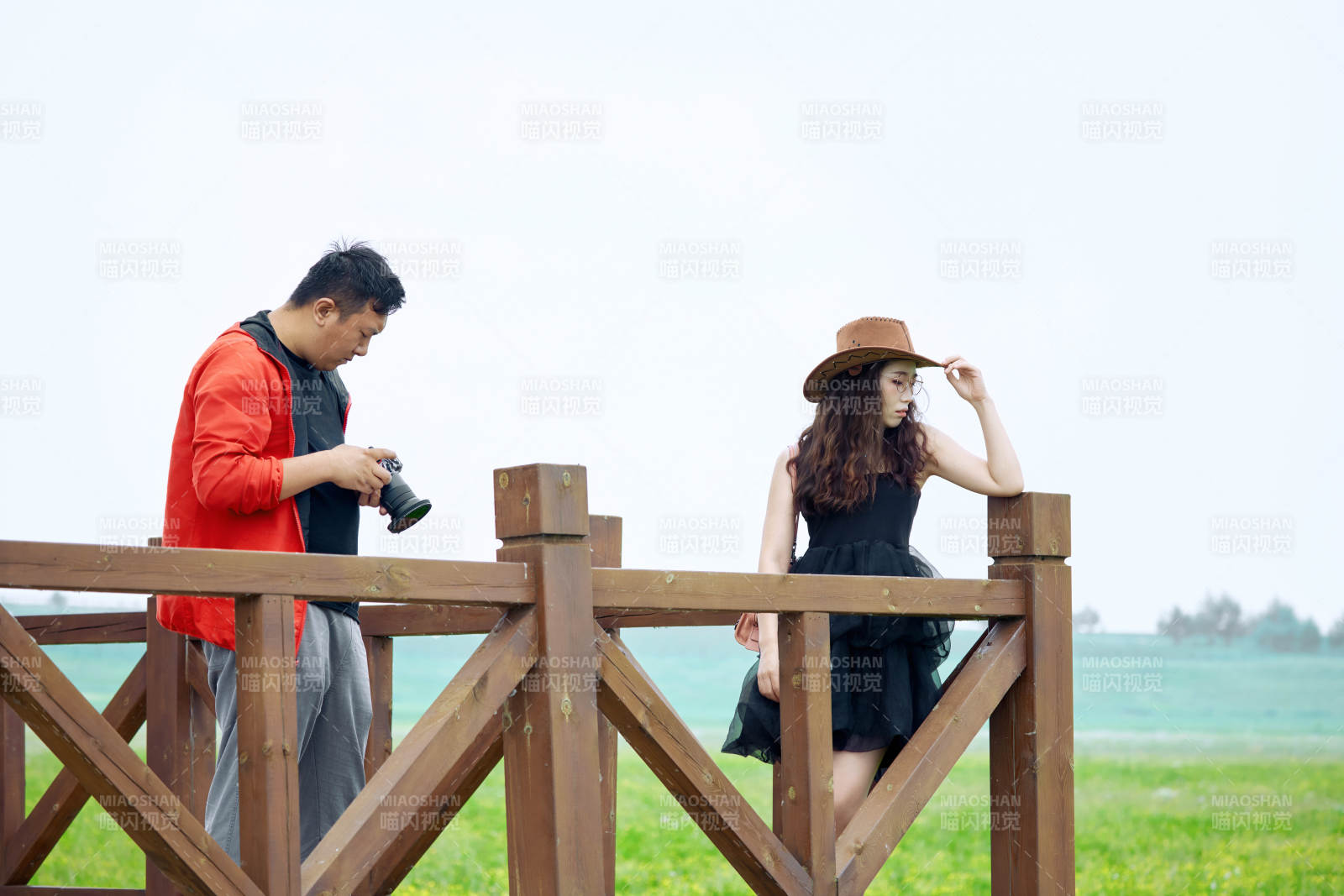 夏天在草原景区拍照的摄影师与模特