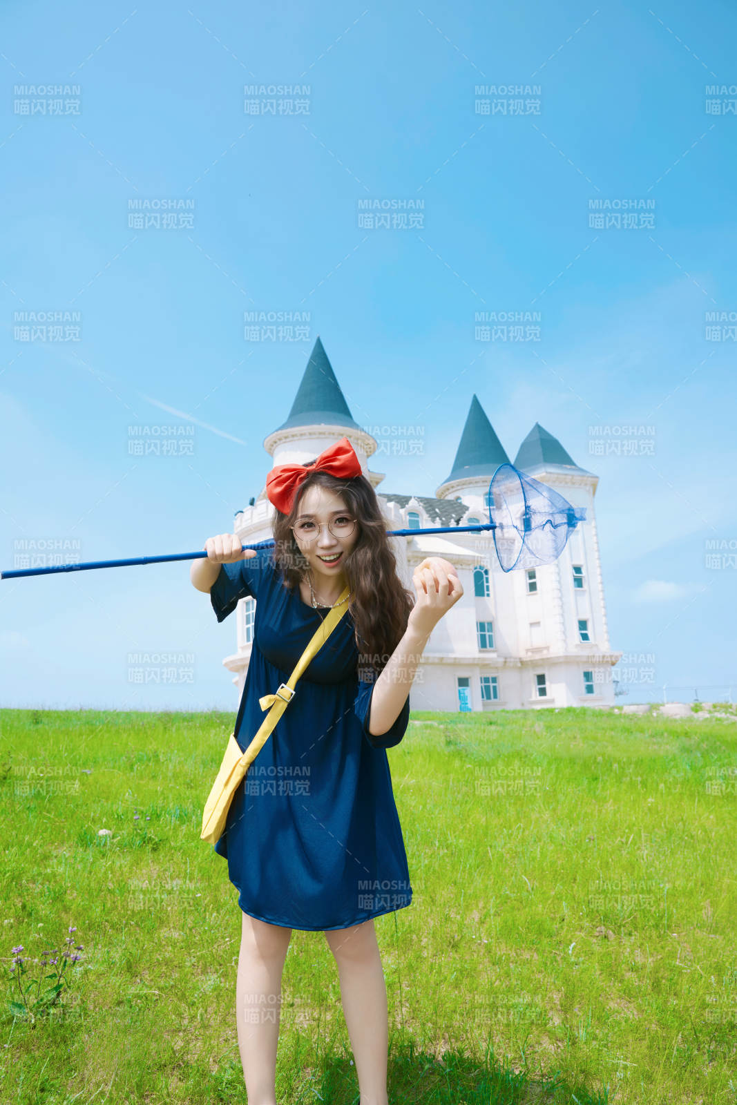 身穿小魔女服饰在城堡前拍照打卡的亚洲美女