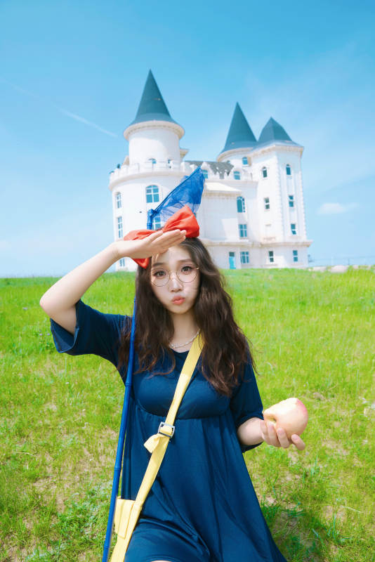 身穿小魔女服饰在城堡前拍照打卡的亚洲美女