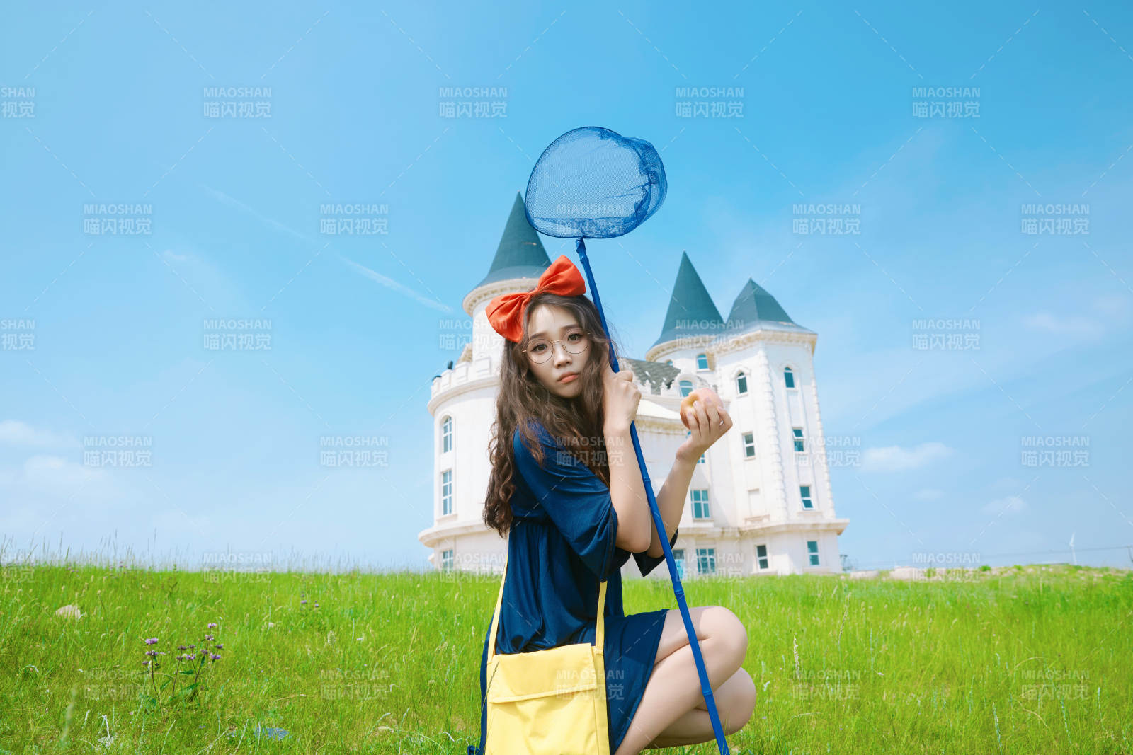 身穿小魔女服飾在城堡前拍照打卡的亞洲美女