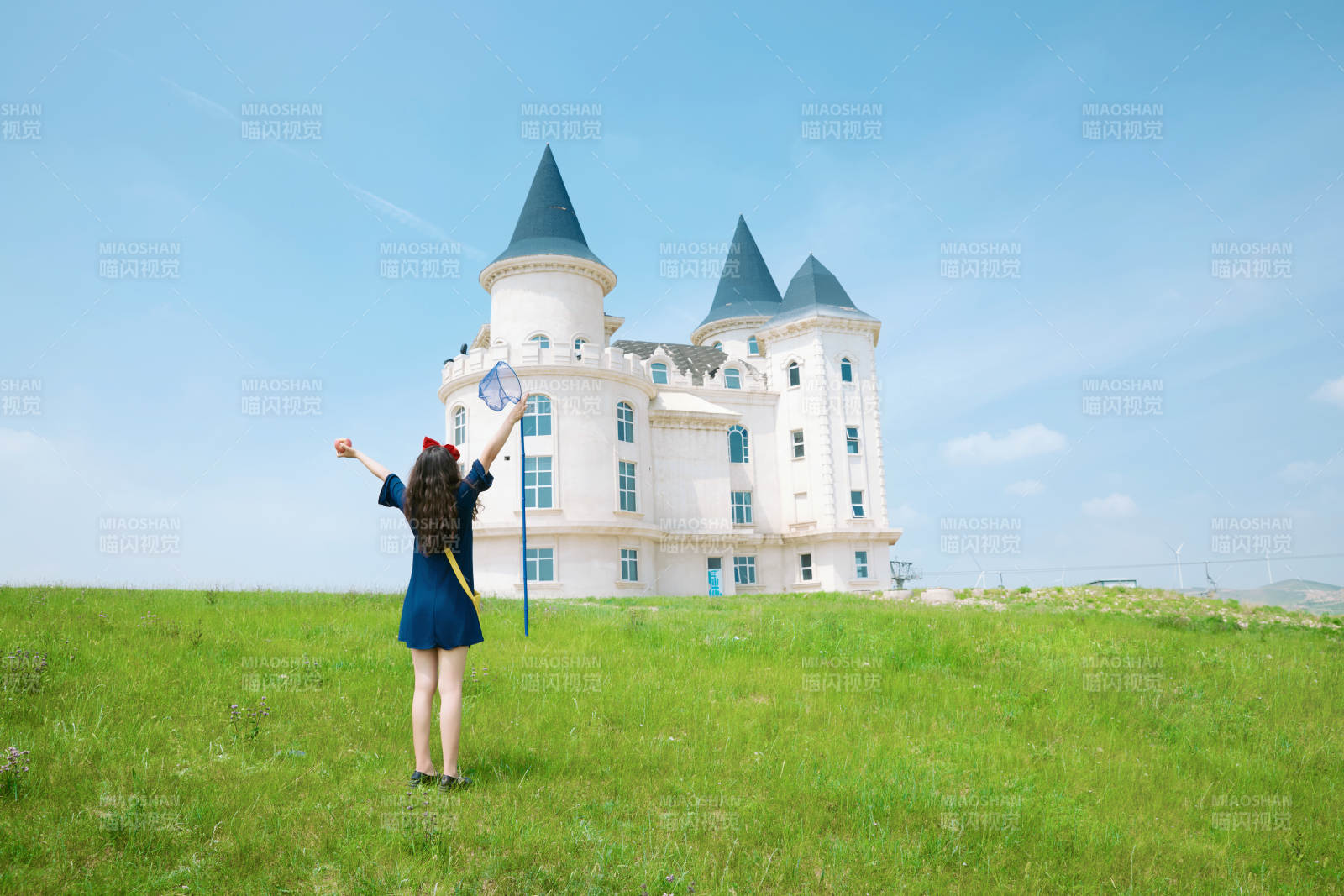 身穿小魔女服饰在城堡前拍照打卡的亚洲美女