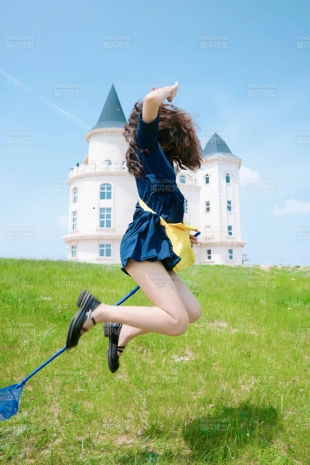 身穿小魔女服饰在城堡前拍照打卡的亚洲美女