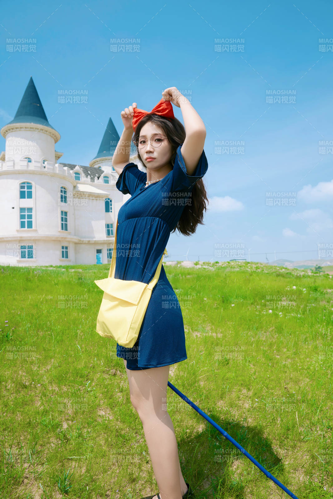 身穿小魔女服饰在城堡前拍照打卡的亚洲美女