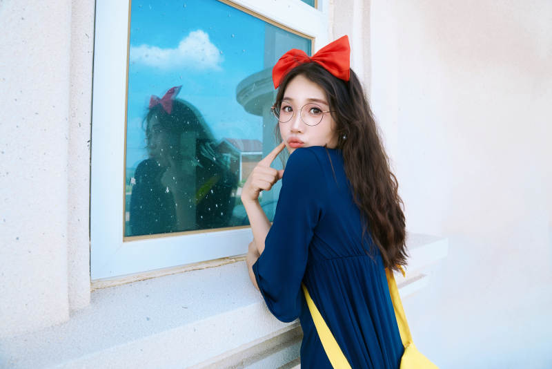 身穿小魔女服饰在城堡前拍照打卡的亚洲美女