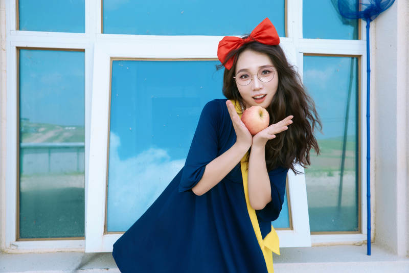 身穿小魔女服饰在城堡前拍照打卡的亚洲美女