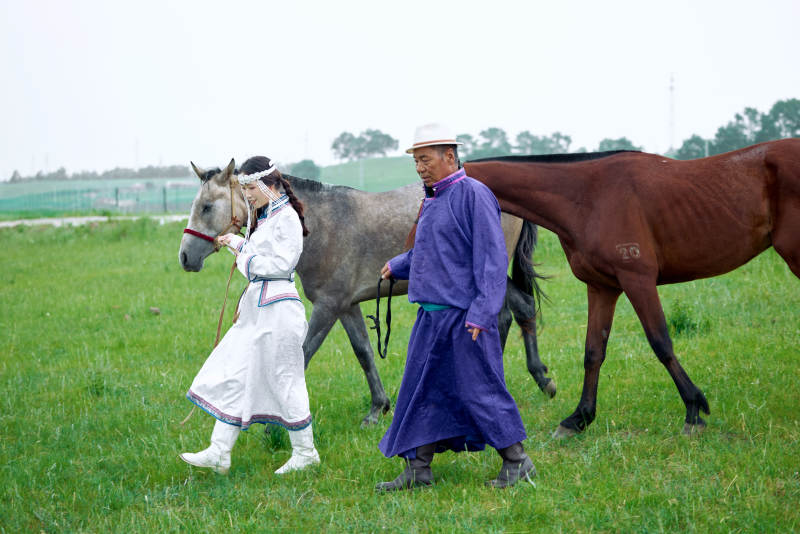 在草原放牧的蒙古族牧民父女