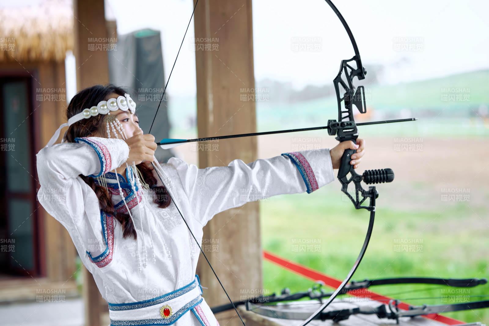 在草原景區(qū)靶場(chǎng)射箭的蒙古族美女
