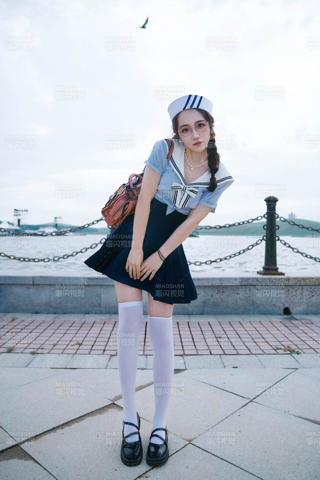 身穿水兵服在湖畔打卡拍照的亞洲美女