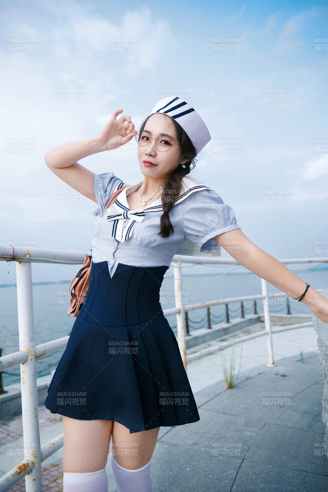 身穿水兵服在湖畔打卡拍照的亚洲美女