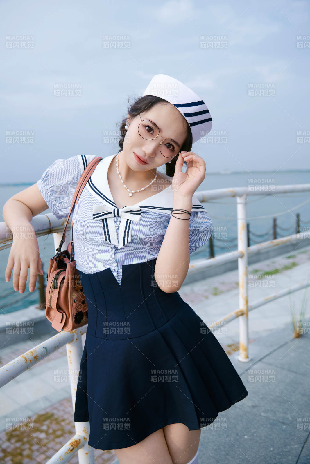 身穿水兵服在湖畔打卡拍照的亞洲美女