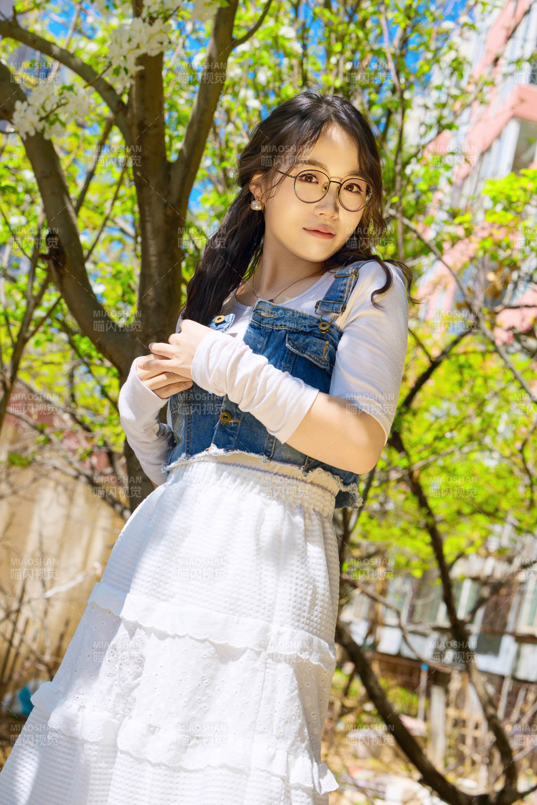 春天在梨花树下拍照的东方美女