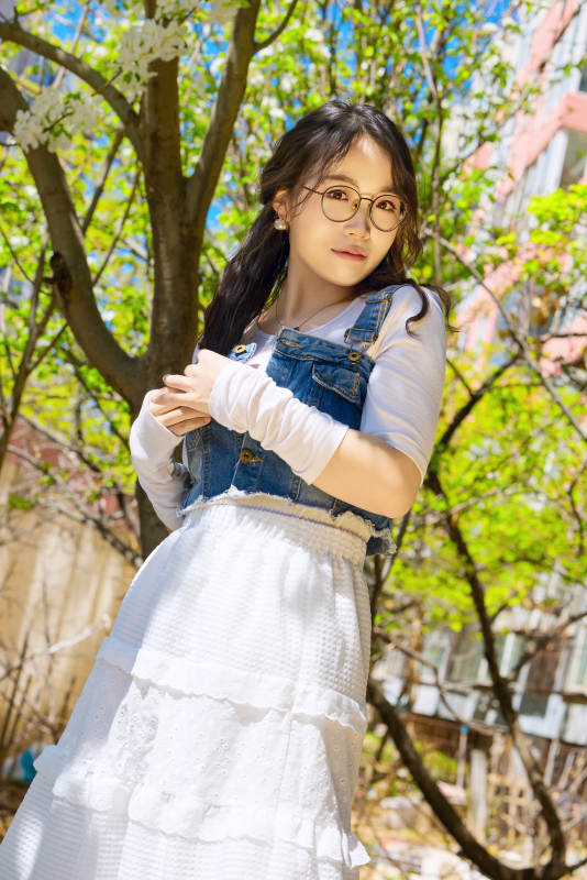 春天在梨花树下拍照的东方美女