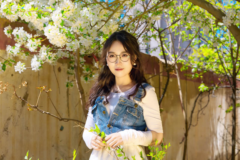 春天在梨花树下拍照的东方美女