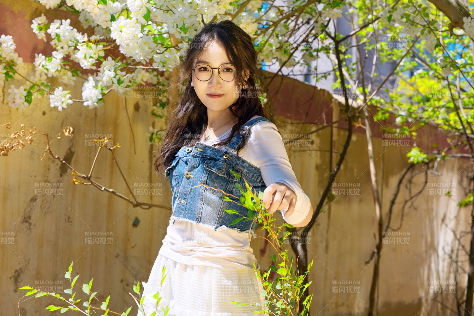 春天在梨花树下拍照的东方美女