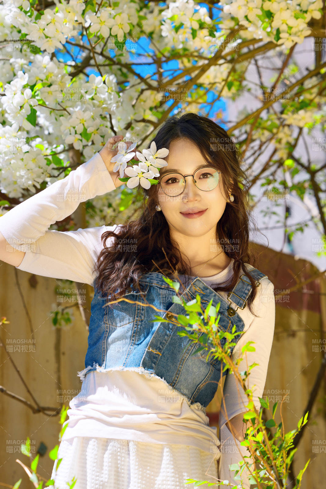 春天在梨花樹下拍照的東方美女