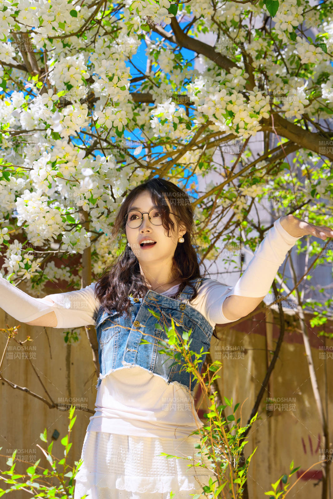 春天在梨花樹下拍照的東方美女