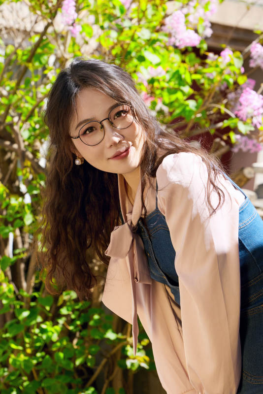 春天在梨花树下拍照的东方美女