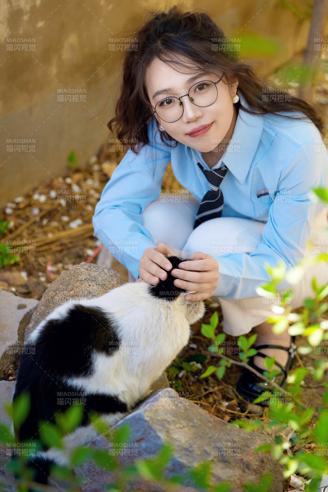 在小區(qū)里投喂流浪貓咪的東方女性