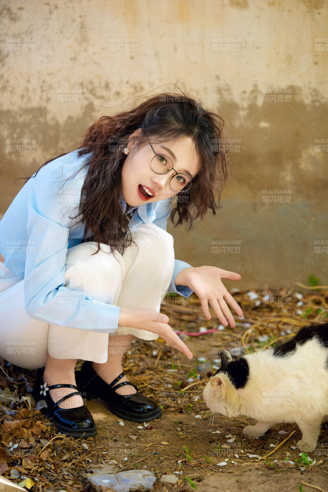 在小區(qū)里投喂流浪貓咪的東方女性