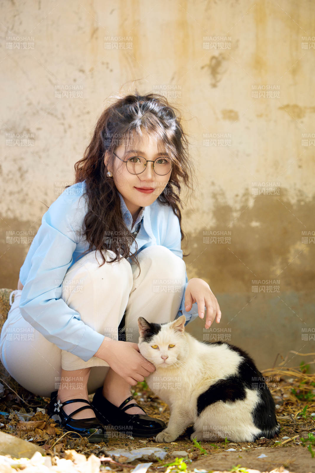 在小区里投喂流浪猫咪的东方女性