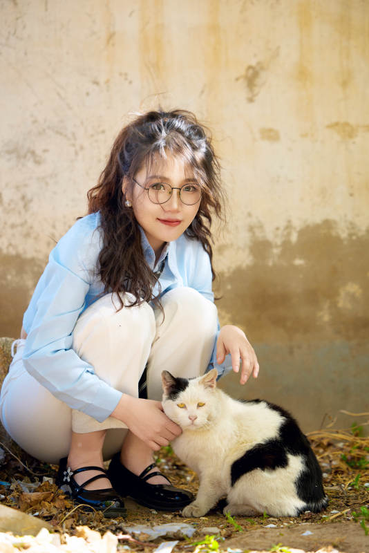 在小区里投喂流浪猫咪的东方女性