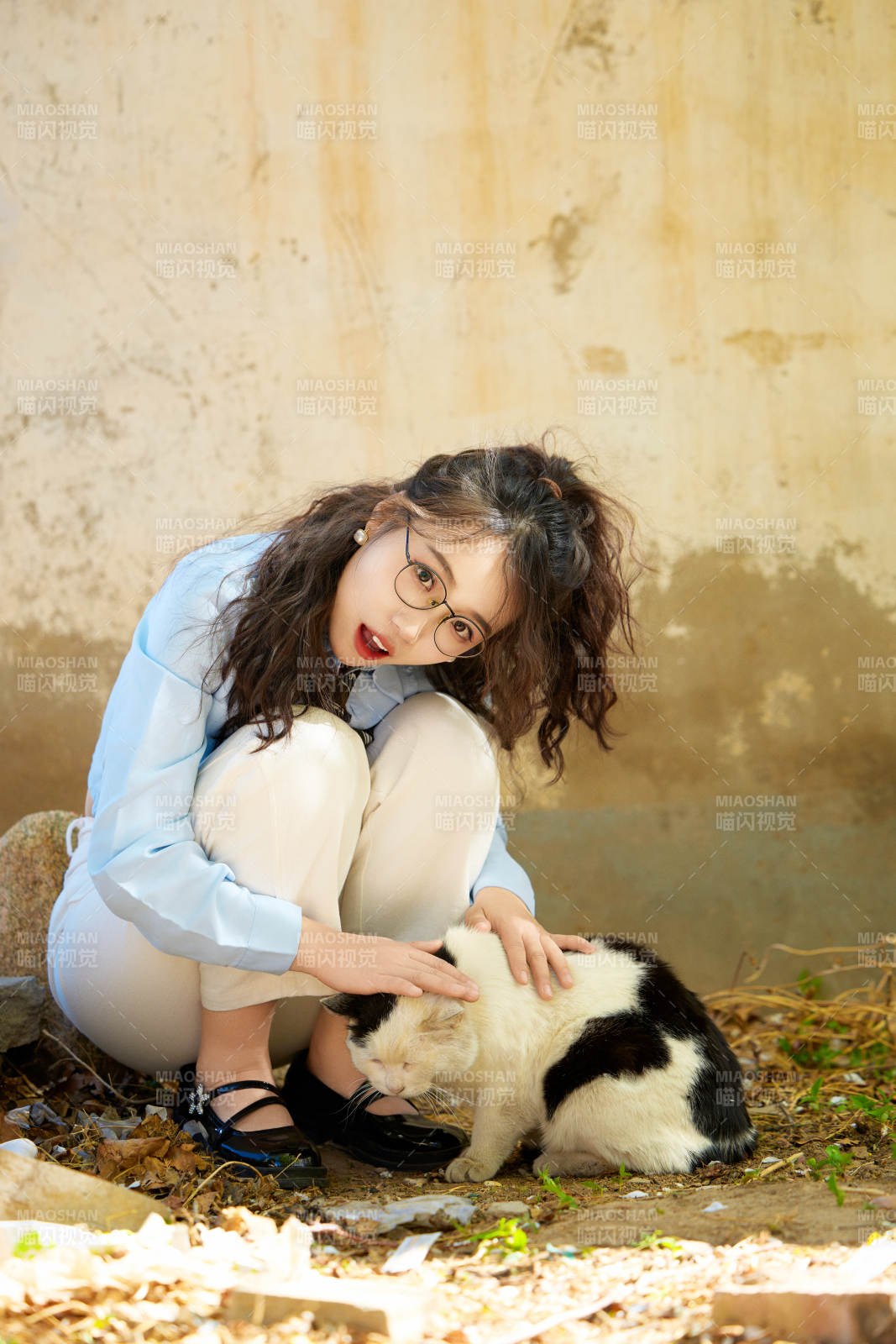 在小區里投喂流浪貓咪的東方女性