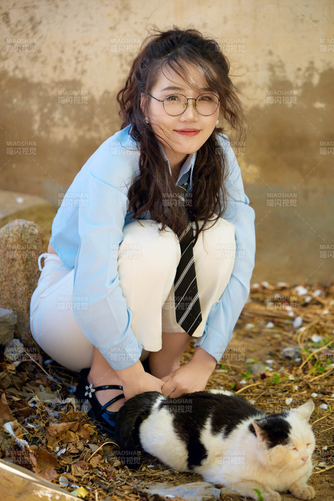 在小區里投喂流浪貓咪的東方女性