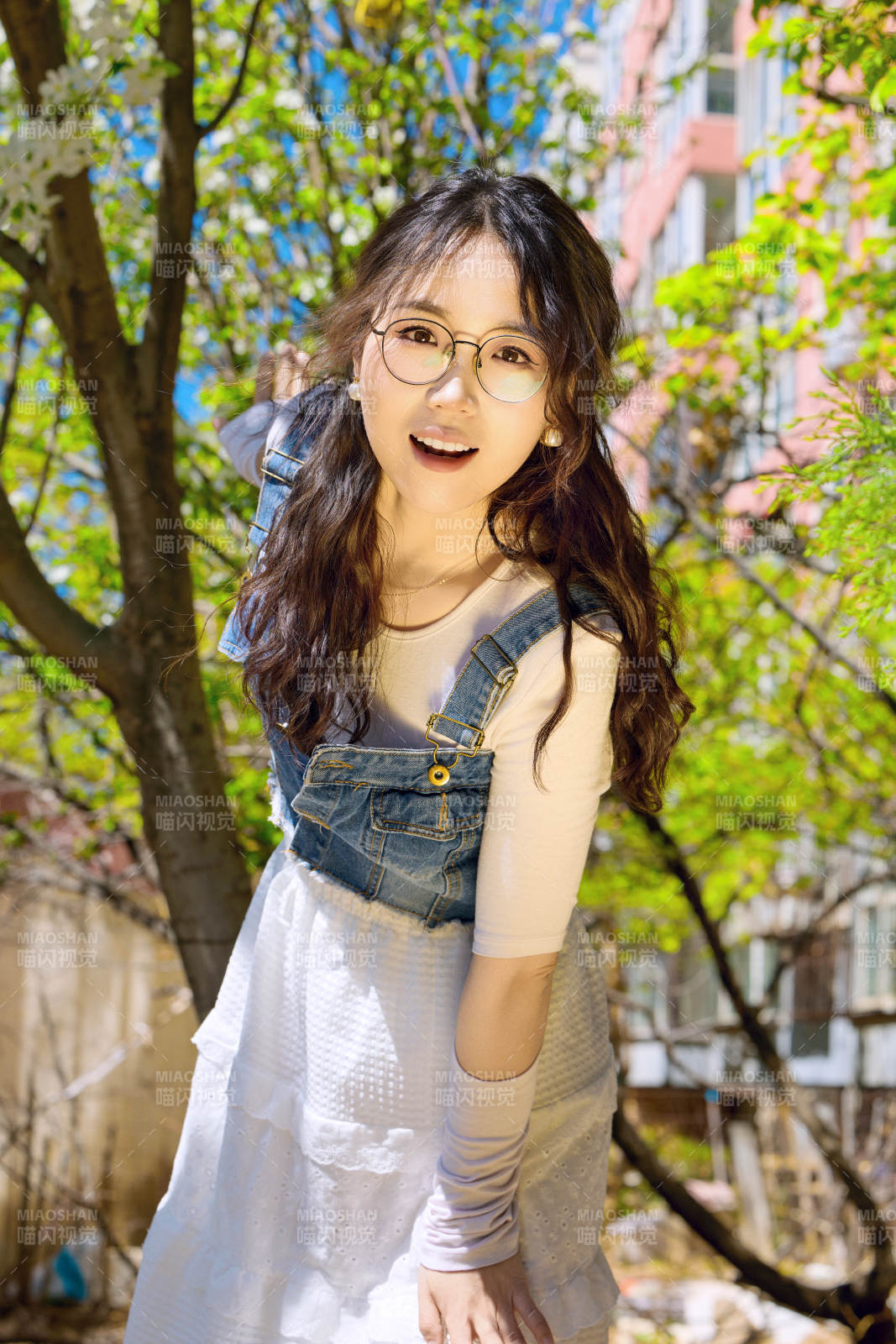 春天在梨花樹下拍照的東方美女