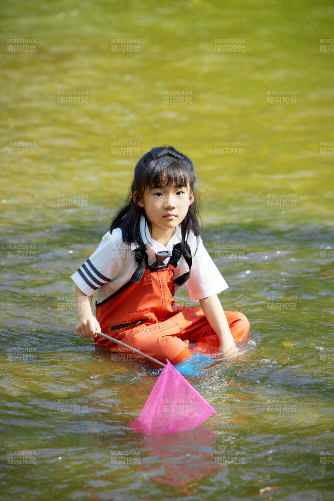 在溪流玩耍捕鱼的可爱亚洲女童