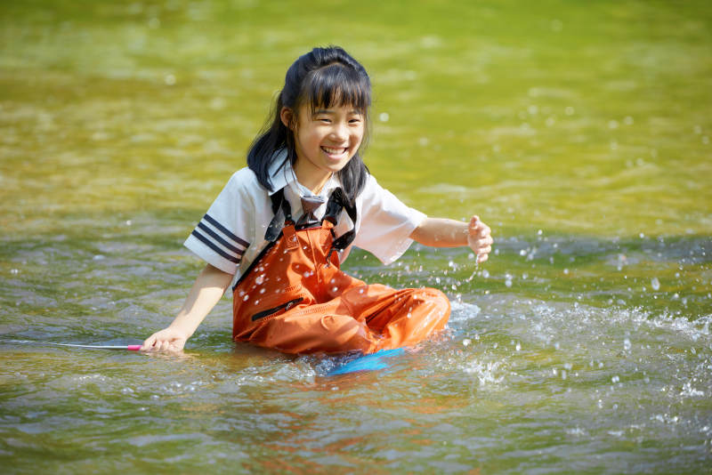 在溪流玩耍捕鱼的可爱亚洲女童