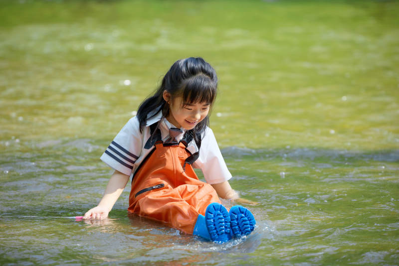 在溪流玩耍捕鱼的可爱亚洲女童