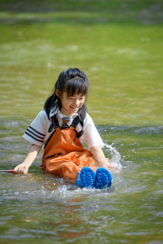 在溪流玩耍捕鱼的可爱亚洲女童