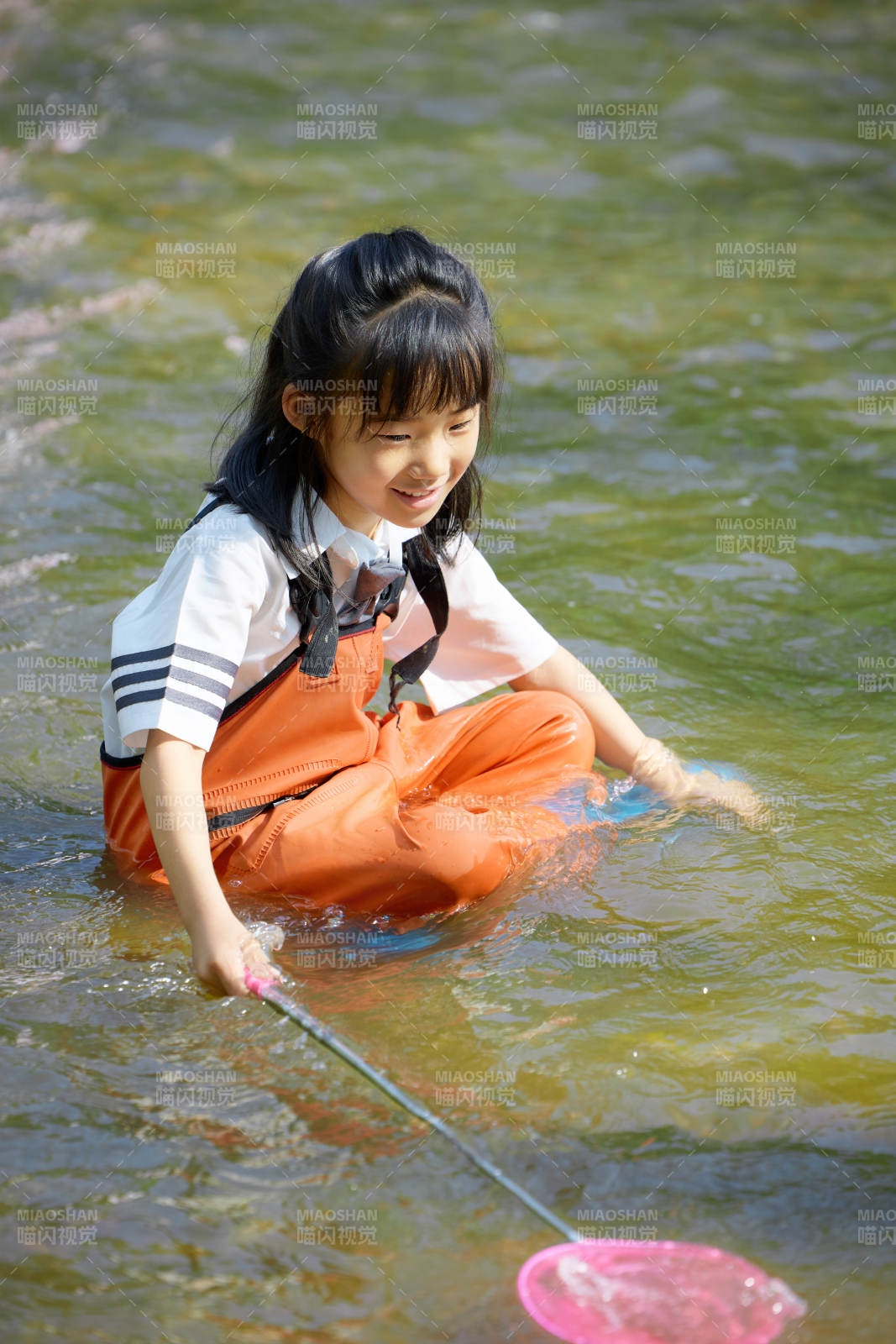 在溪流玩耍捕魚(yú)的可愛(ài)亞洲女童