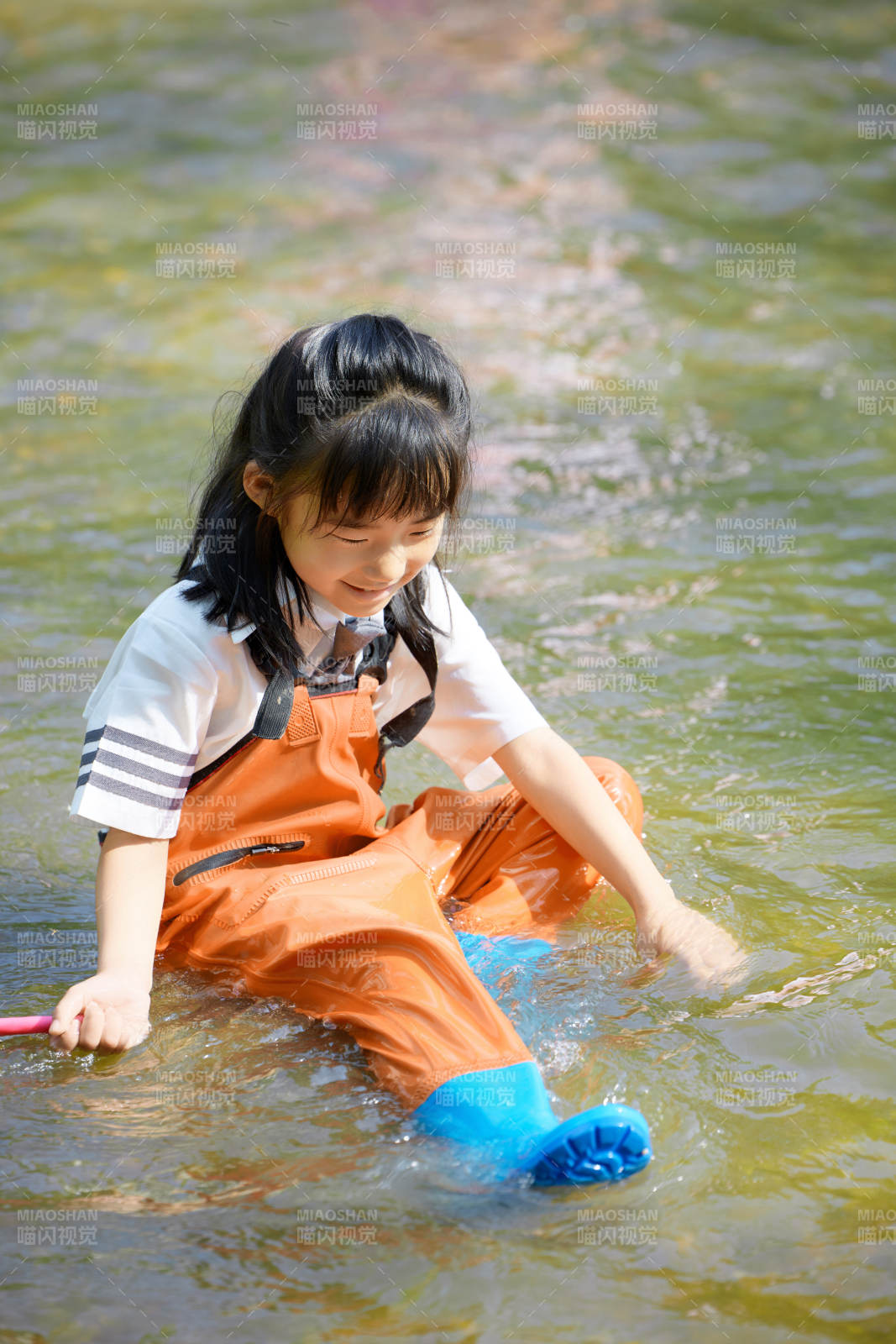 在溪流玩耍捕魚的可愛亞洲女童