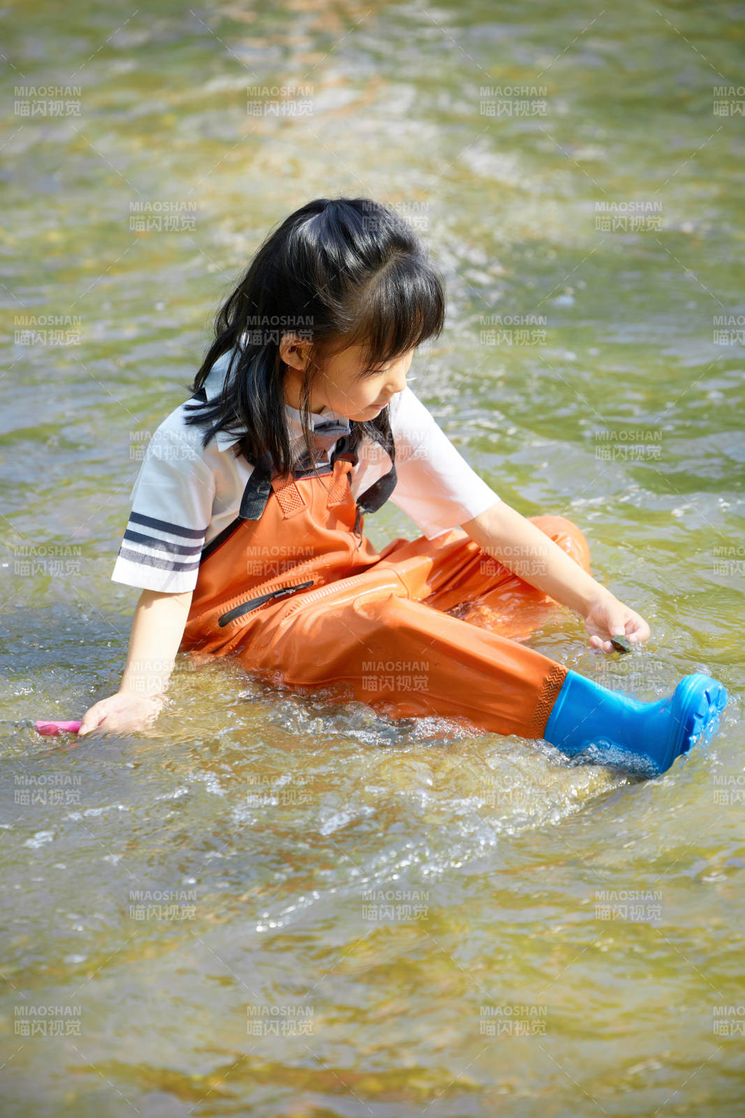 在溪流玩耍捕魚的可愛亞洲女童