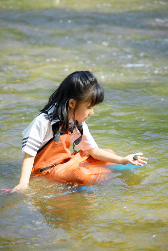 在溪流玩耍捕鱼的可爱亚洲女童