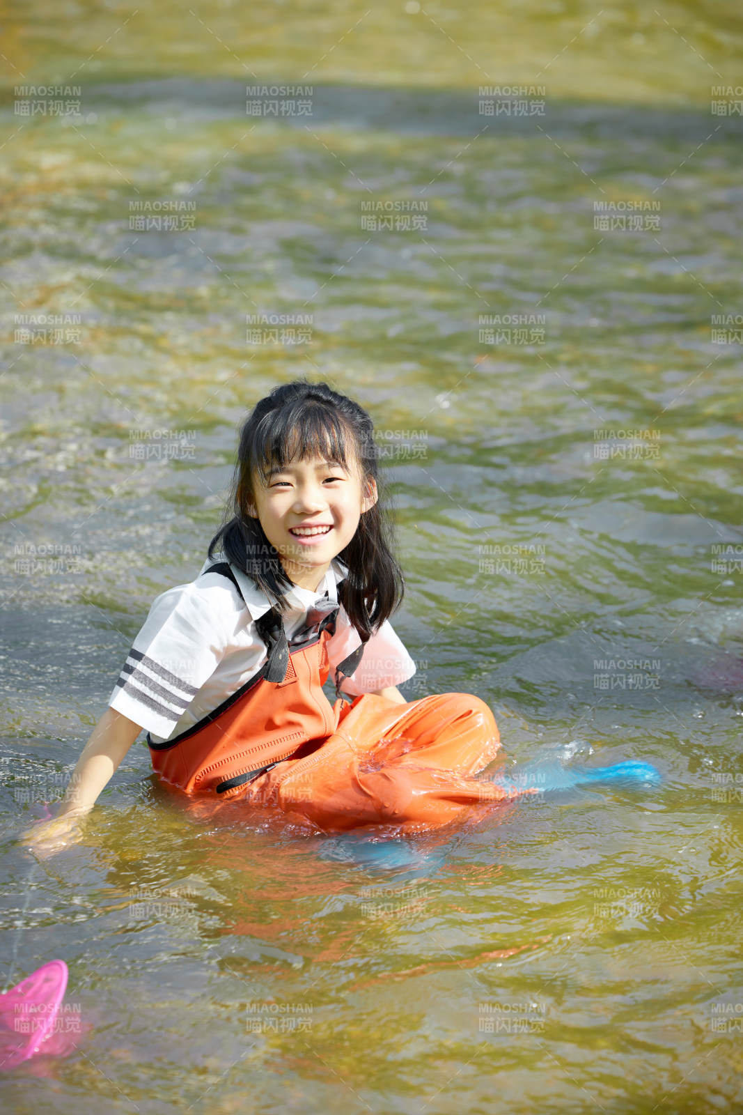 在溪流玩耍捕魚的可愛亞洲女童