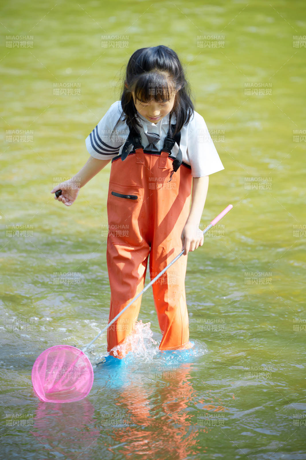 在溪流玩耍捕魚的可愛亞洲女童