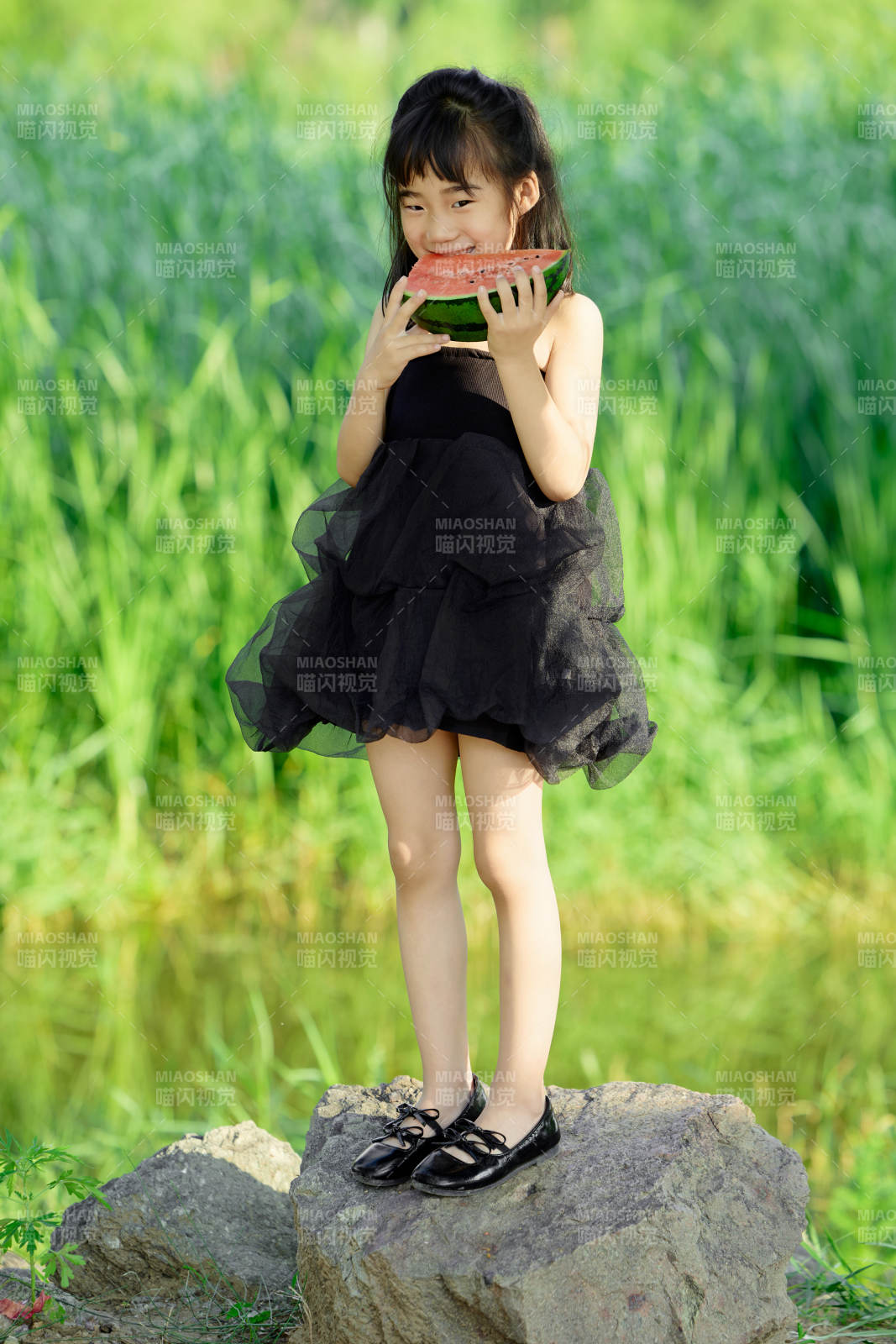夏季在戶外游玩吃西瓜的可愛亞洲女童
